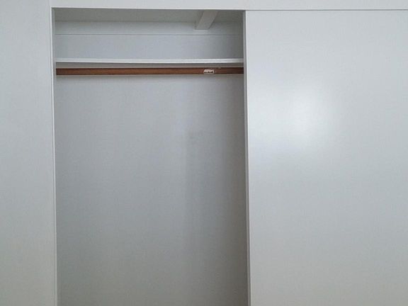 closet in bedroom 1 (note storage above)