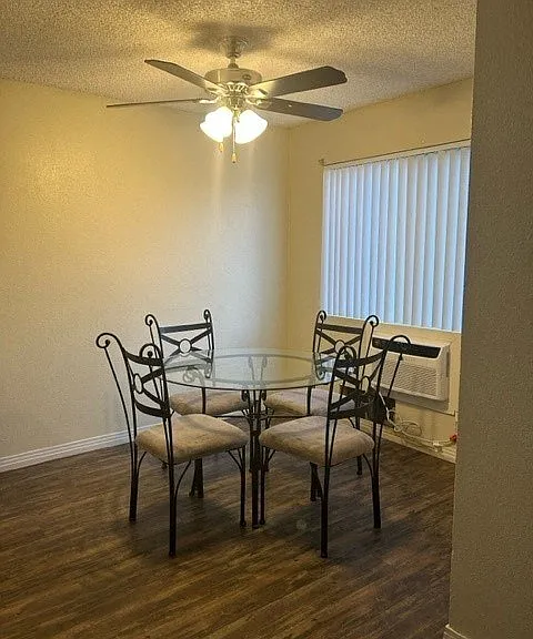 Cozy dining room area with large window and ceiling fan.