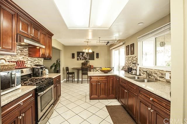 Remodeled kitchen with granite countertops and glass backsplash