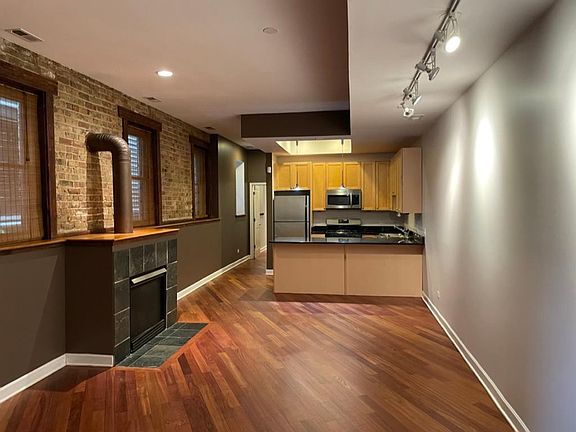 Large open layout with fireplace, kitchen and built in shelfs