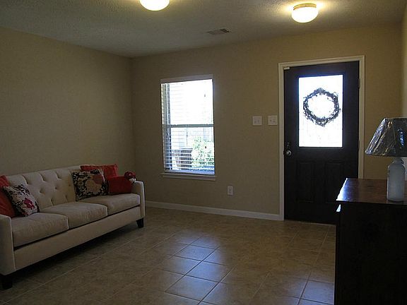 THIS COZY LIVING room has a ton of light. Note the tile all around the first floor an the elegant baseboards.