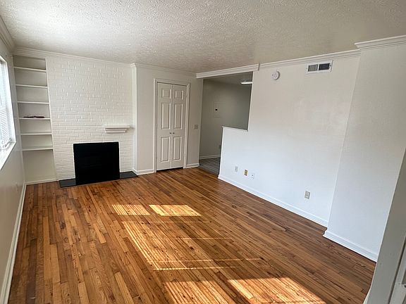 Living room with wood burning fireplace and built ins