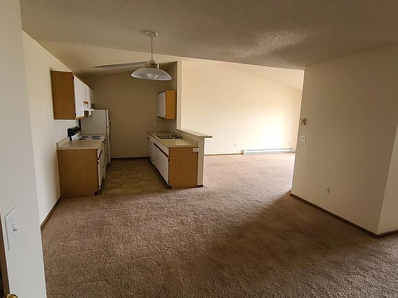 A view of the dining room, kitchen and living room with a bedroom just off to the right.