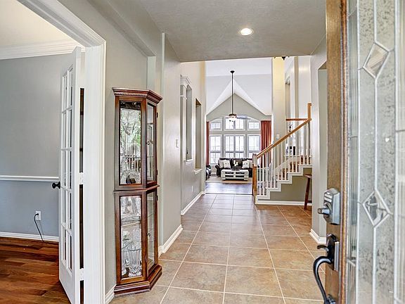 View through the back of the home greet you as you enter. This large two story tiled entry, with decorative art niches, has plenty of room to greet all your guests.