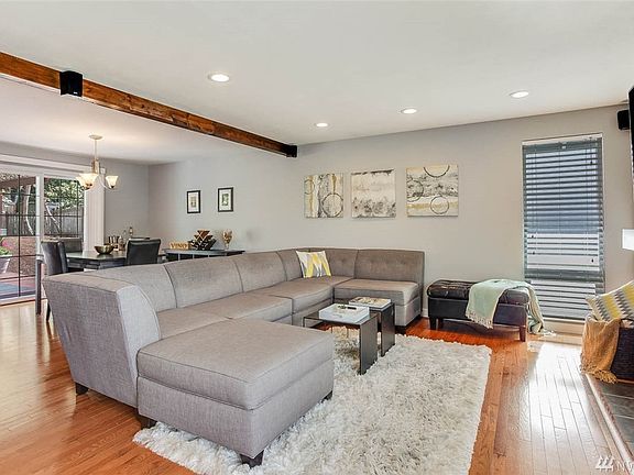 Another view of the living room, open to the dining and kitchen. Check out the gorgeous wood beam, which matches the mantel over the fireplace.