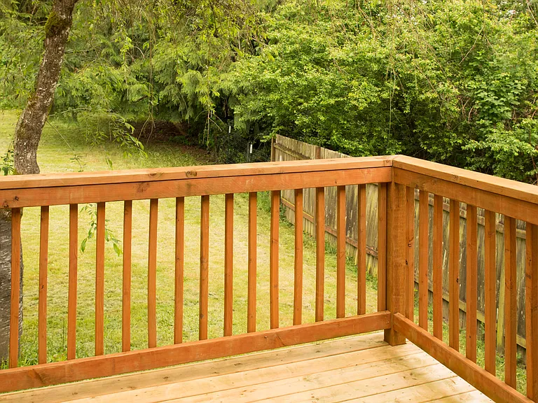 Private deck overlooking a peaceful backyard with mature trees and a quiet natural setting. Great space to relax outdoors.