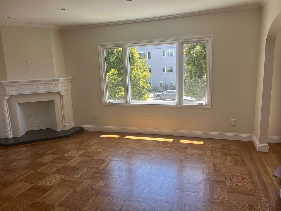 Large living room with fireplace and newly refinished floors and new double panes windows