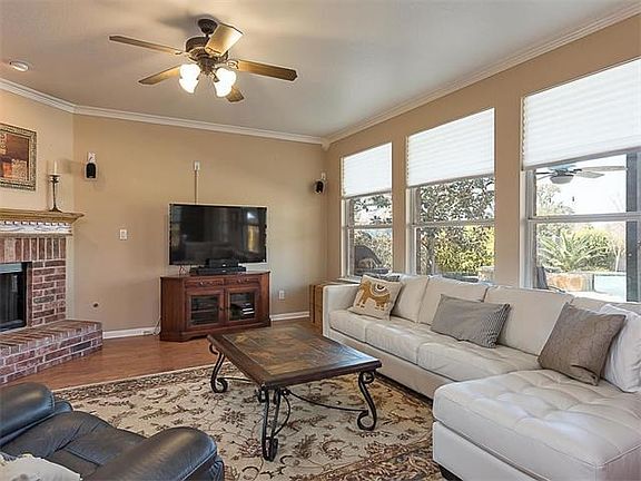 The downstairs family room has a wall of windows overlooking the pool, backyard and greenbelt. The fireplace is offset.