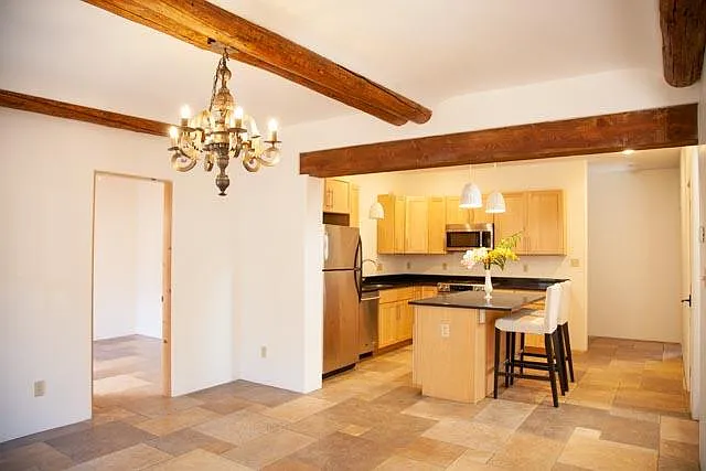 Lovely modern kitchen with granite counters and gas range is off from dining room. Garage entry is in hall behind kitchen to right.
