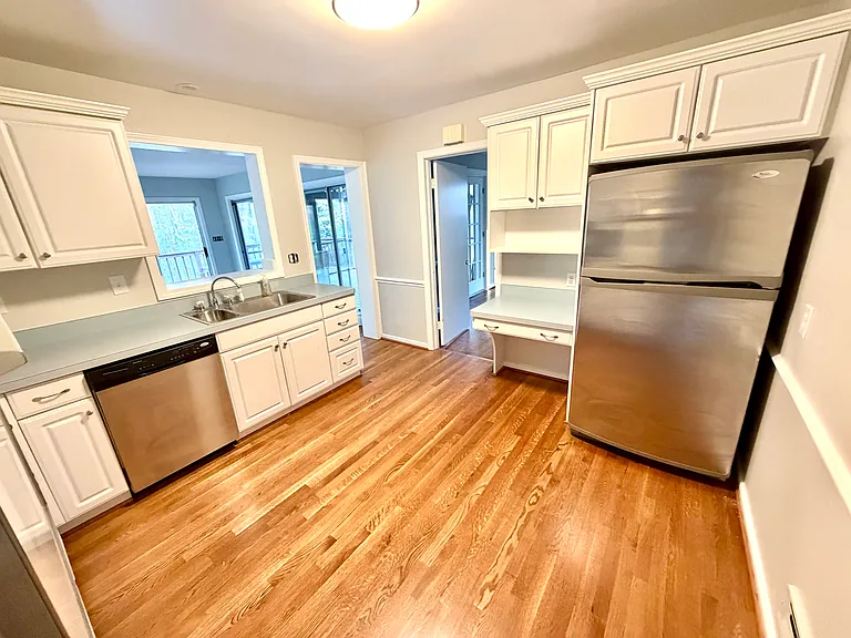 Updated white kitchen with refrigerator. Overlooks the Sunroom addition.