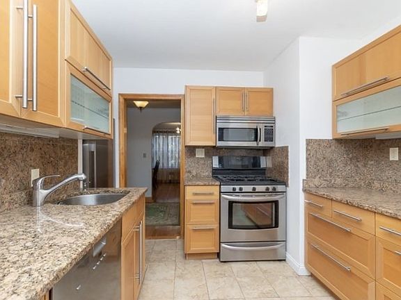 View of kitchen looking into living/dining; gas stove and more storage/prep space