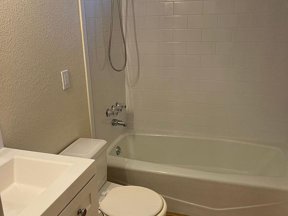 Bath area with bowed rod for shower curtain. Water resistant flooring. Top drawyer pulls out from the sink.