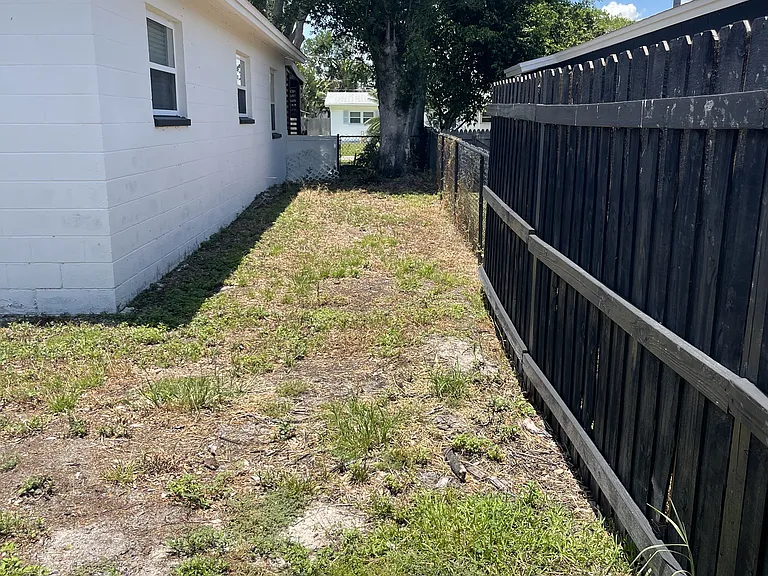 left side of the back yard leading to the front of the house.