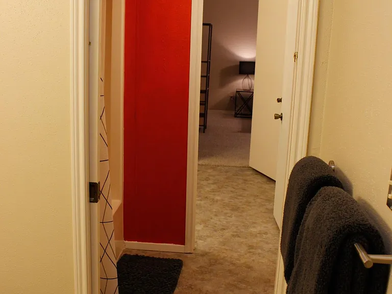 Looking back through the connecting doors from the second restroom to the shared bath/shower.