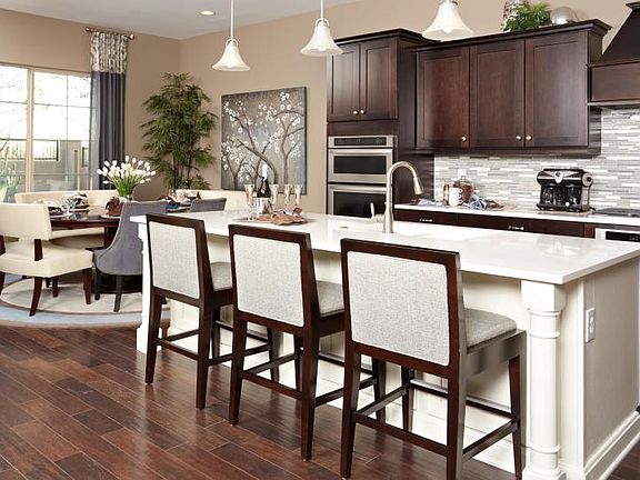 Upgraded kitchen with staggered cabinets and an island surrounded by the cozy cafe and gorgeous wood