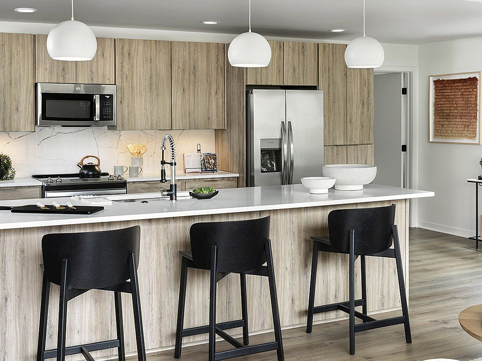 Apartment Kitchen with Stainless Steel Appliances, quartz counters and wood floors.