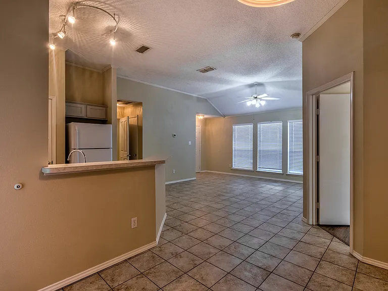 View from dining area to living area; door to primary bedroom on right