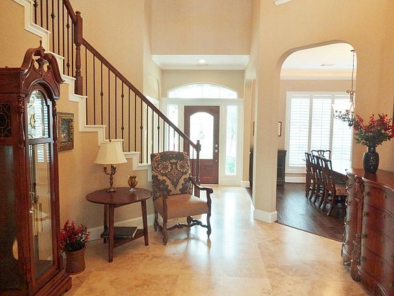 Grand two story entry with travertine floors, arched entries