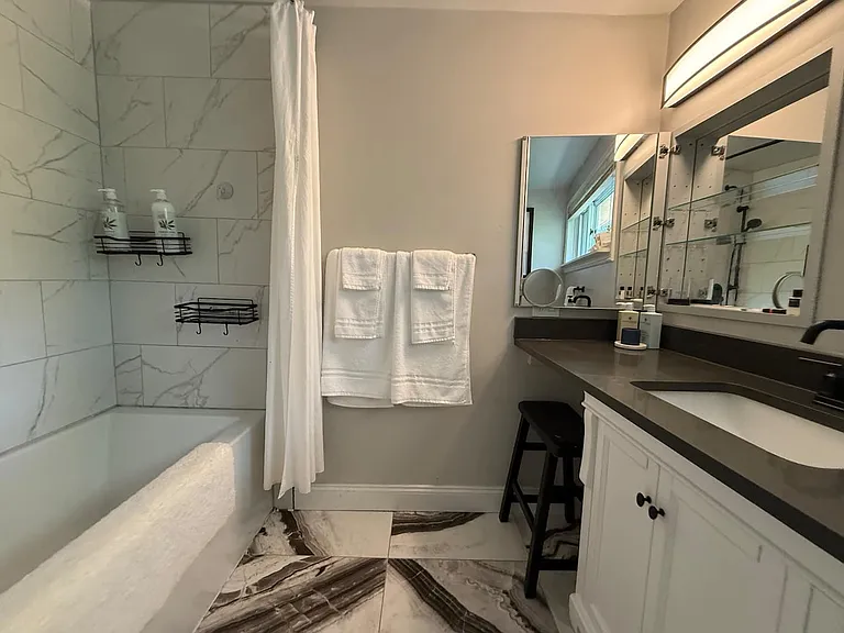 Spa-style bathroom with heated tile floors, Toto Washlet heated bidet, soaking tub, and full vanity with mirrored medicine cabinet storage