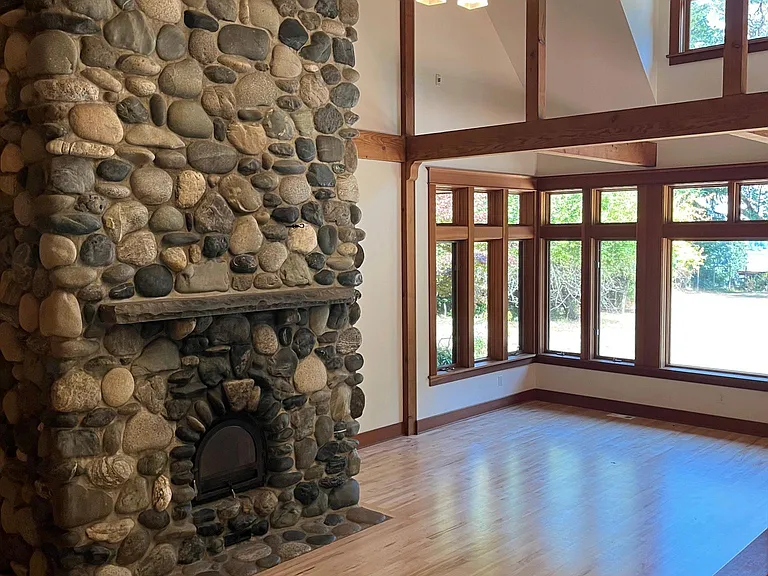 Living room, featuring soaring ceilings and river rock fireplace.