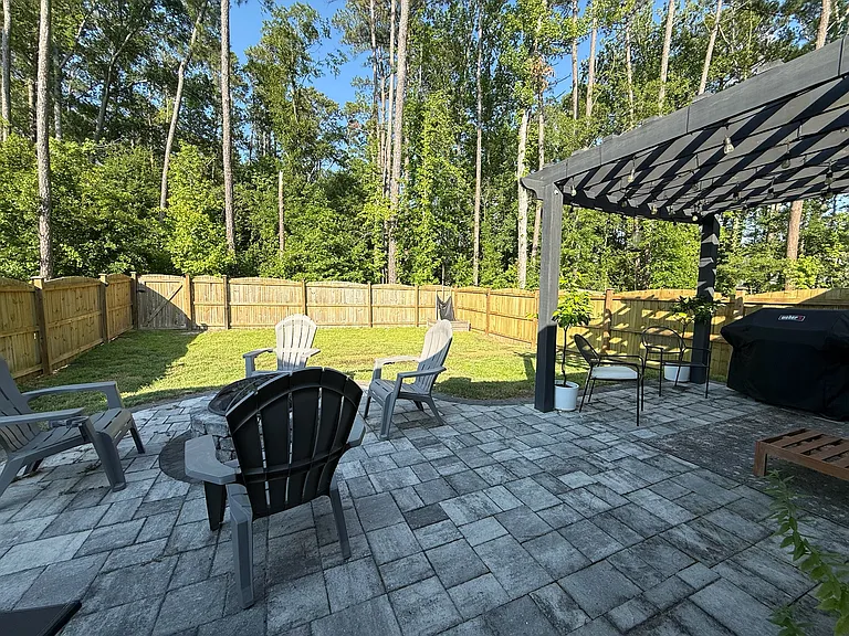 Backyard patio area with fire pit and pergola