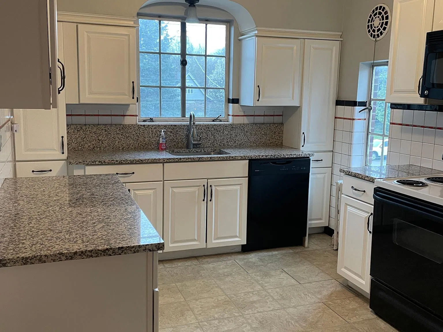 This light filled kitchen features granite and white cabinetry