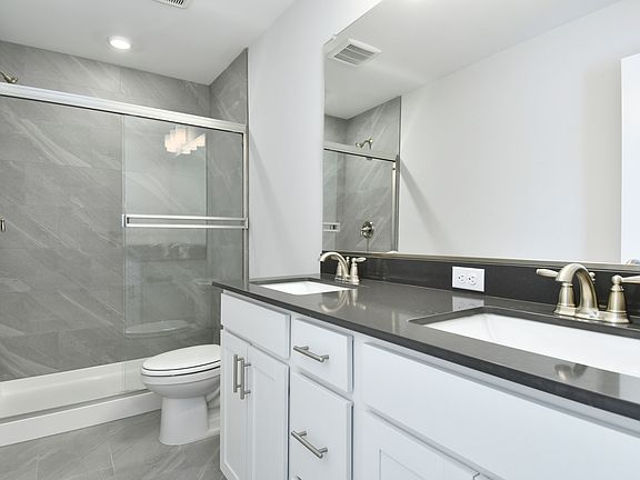 The master bathroom has a dual sink vanity and a step in shower.
