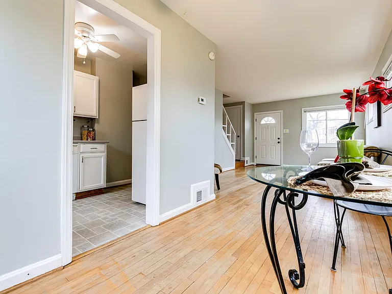 Hardwood floors now stained a darker color and wall on left to be removed during kitchen reno