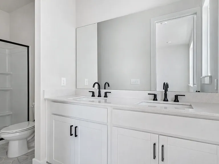 Primary bathroom with double vanity and modern fixtures