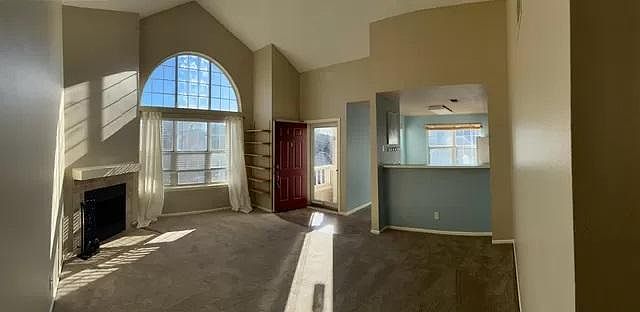 Panoramic view of living room looking into kitchen. New carpet and paint.
