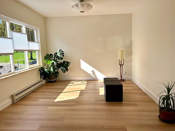 Living room with high ceilings and double pane windows, top/down blinds.