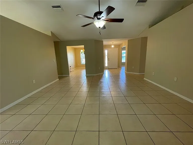 view of front door and 2 open spaced rooms at front of the home