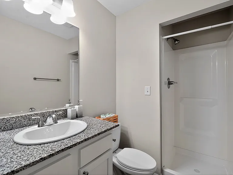 Contemporary bathroom with elegant granite countertop, sleek fixtures, and a spacious walk-in shower. Contemporary bathroom with elegant granite countertop, sleek fixtures, and a spacious walk-in shower.