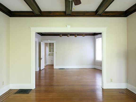 Living room and dining room with beautiful original wood bea