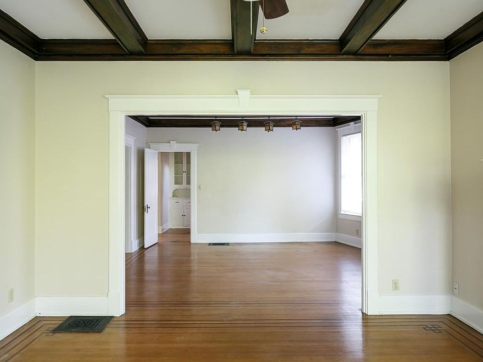 Living room and dining room with beautiful original wood bea