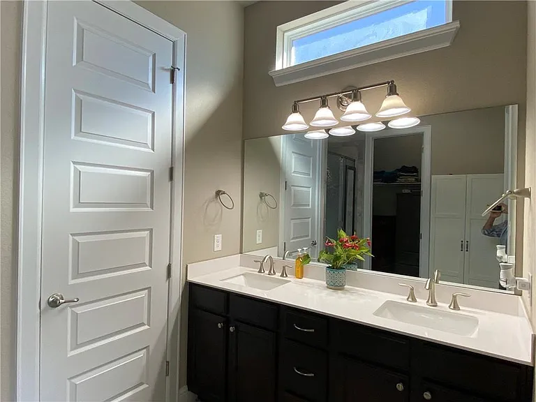Master bath with 2 sinks and entry to closet