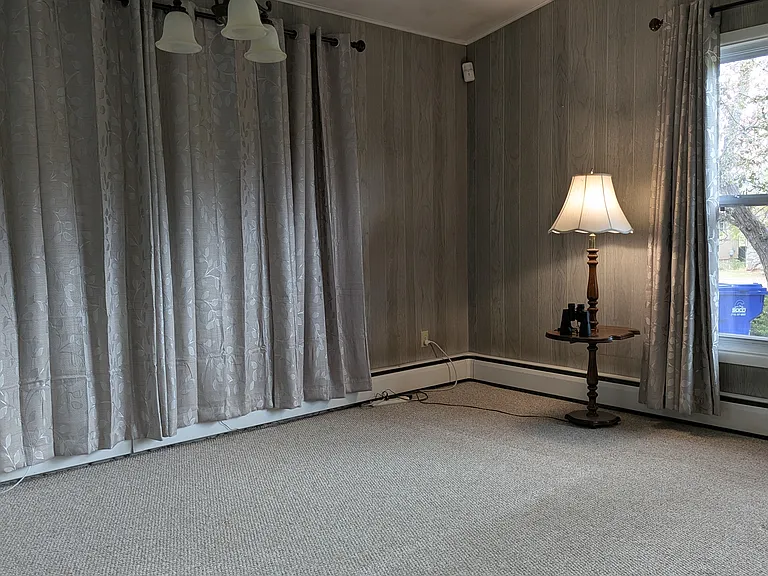 Dining area in main living room. Curtained windows face the carport.