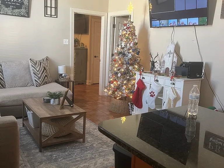 A view of the living room from the kitchen facing into the entry of the bedroom.