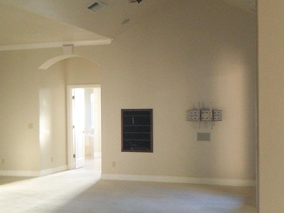 View from kitches adross great room to entry into master suite. Media shelving built into wall with total access from "his" closet.