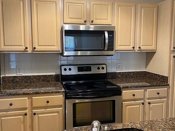 Kitchen with New LED Track Lighting, all Stainless Steel Appliances, and Granite Counters.