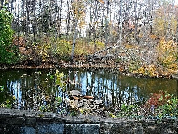 Stone walls surround a pond that once had a dock thats just waiting to be rebuilt.