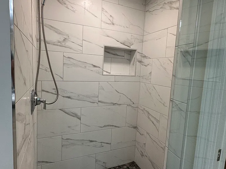 Master shower offers natural stone flooring and elegant tile for those luxurious shower moments