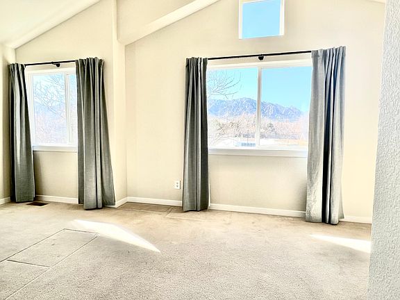Two windows in the primary bedroom have a beautiful view of the Flatirons