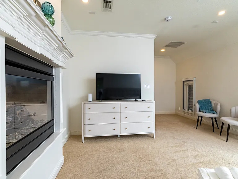 Relaxing upstairs lounge featuring a second TV and fireplace.