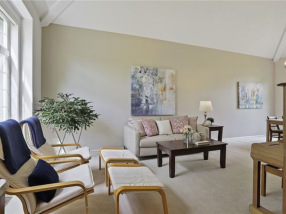 The formal living room features tons of space for gatherings! The vaulted ceiling here allows for natural light to pass through!