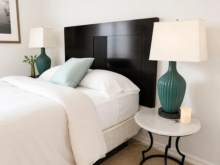 Well-appointed bedroom featuring a bed with a statement headboard, matching bedside lamps, and convenient nightstands.