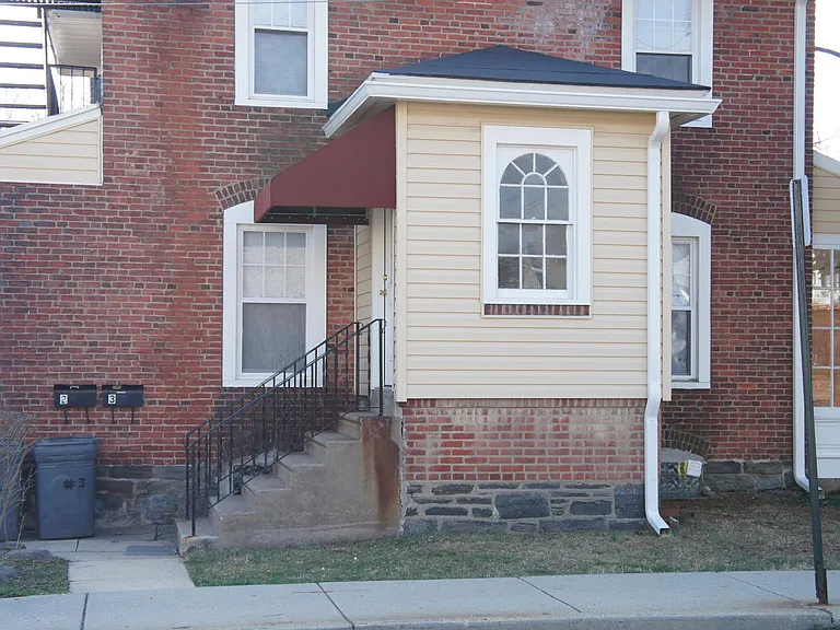 Steps leading up to Apt 3 (and Apt 2) -and on other side of stairs, a set of stairs leading down to basement via outside Bilco doors.