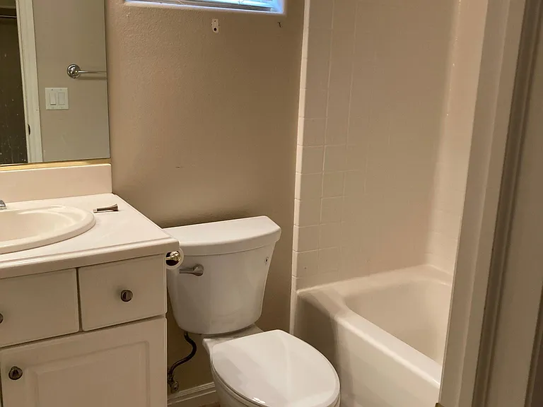 Bathtub/shower with sink and toilet in the middle of the two bedrooms.