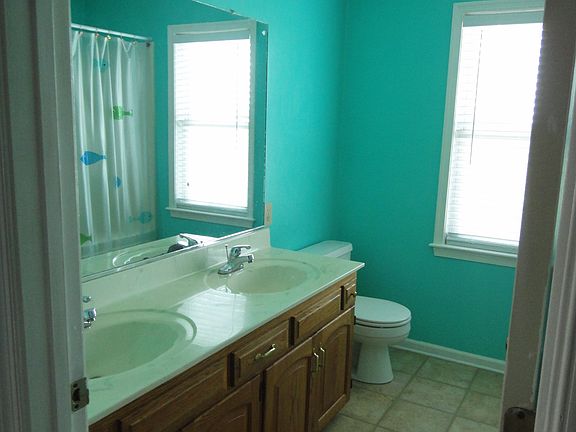 Full bath in the upper level hallway has a double sink vanity and 