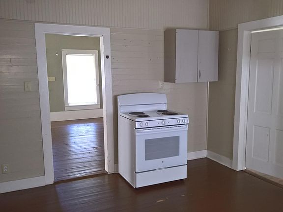 Kitchen range and space for refrigerator. Owner can furnish refrigerator if desired.
